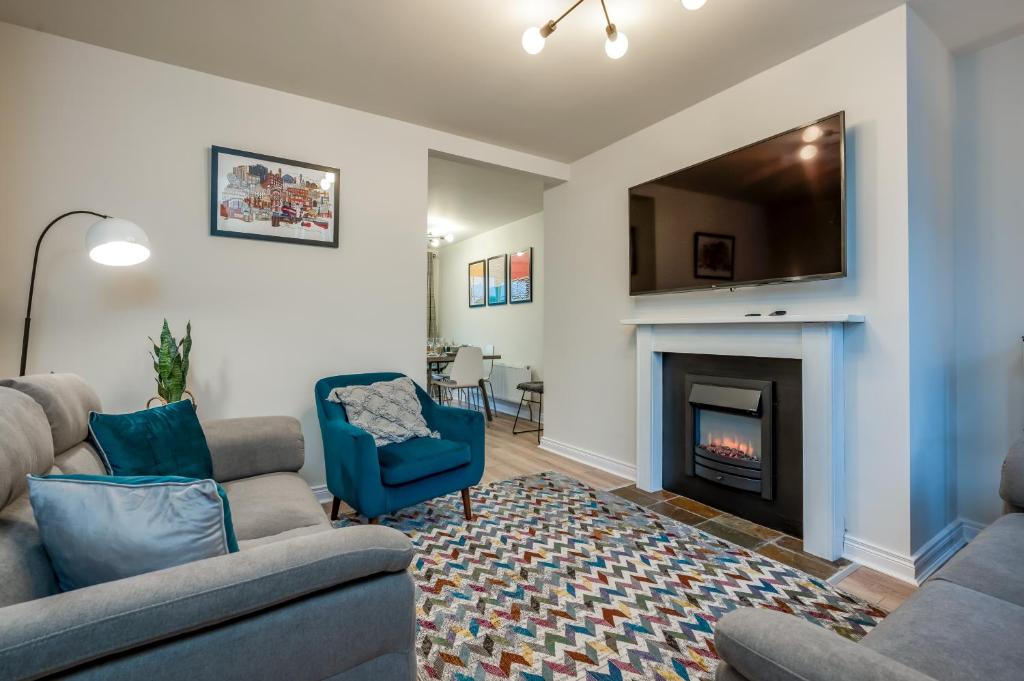 a living room with two couches and a fireplace at Central Belfast Apartments: Ashley Mews in Belfast
