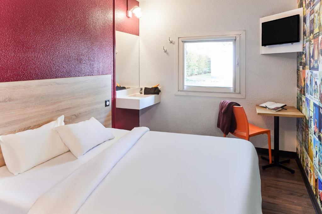 a hotel room with a bed and a window at hotelF1 Lorient in Caudan