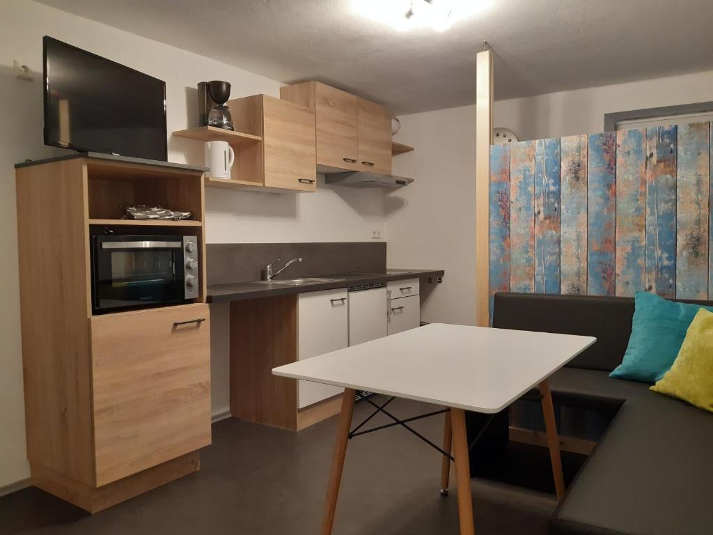 una pequeña cocina con mesa blanca y microondas en Your BaseCamp!, en Roppen