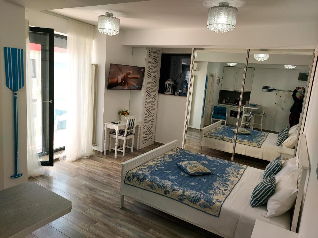 een kamer met 2 bedden en een spiegel bij Bluemarina Apartamente in Mamaia