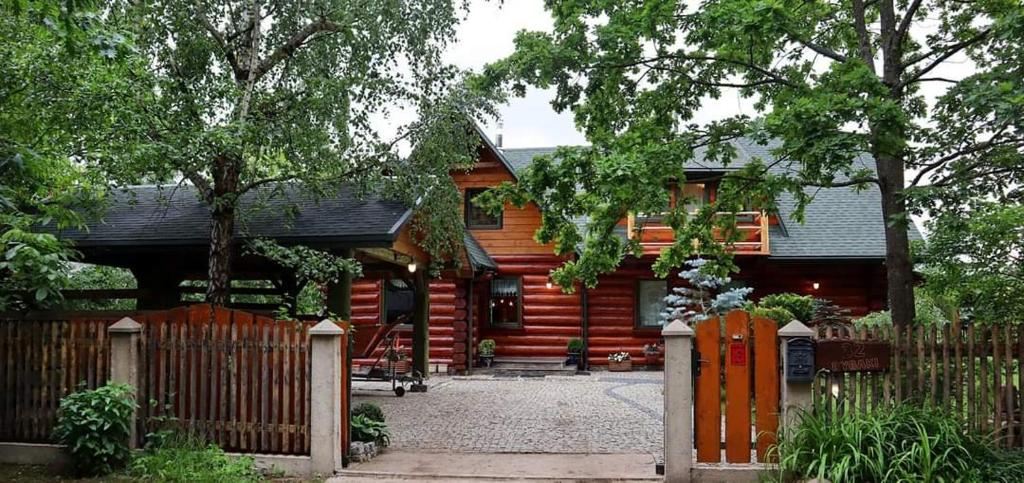 una cabaña de madera con una valla delante en Willa Siemianówka - Sauna, Jacuzzi en Rybaki