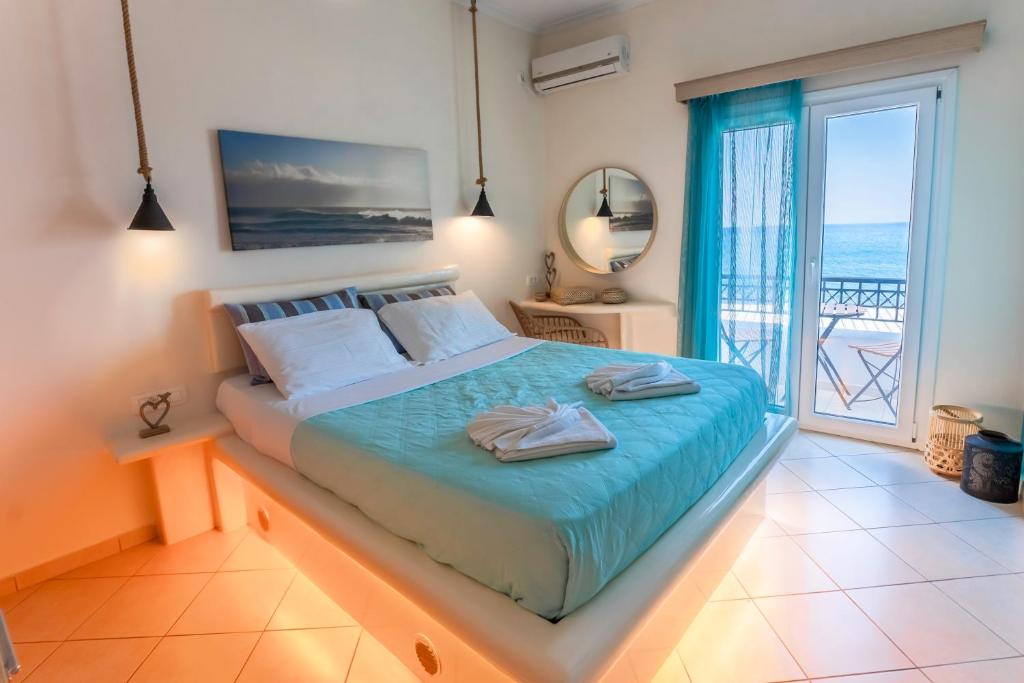 a bedroom with a bed with a view of the ocean at Sagma calm apartment with amazing sea view in Perissa