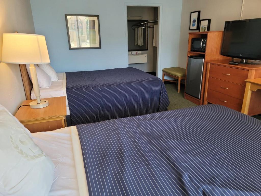 亨德森的住宿－121 Motel Henderson，酒店客房设有两张床和电视。