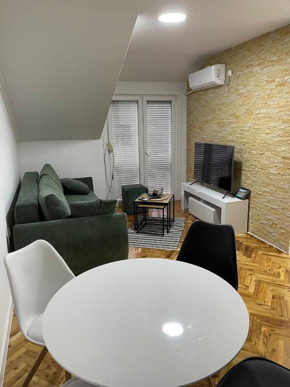 a living room with a white table and a couch at Stan centar ns in Novi Sad