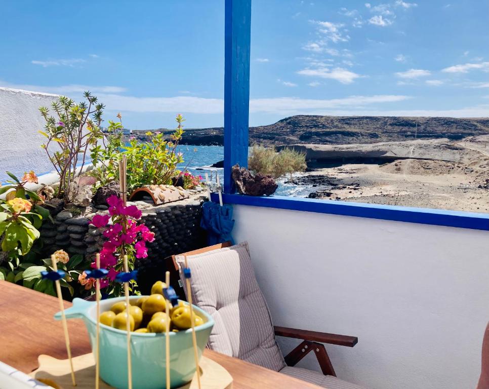 un tavolo con un cesto di frutta sul balcone di Casa Dora: Tradicional y al borde del mar. a Poris de Abona