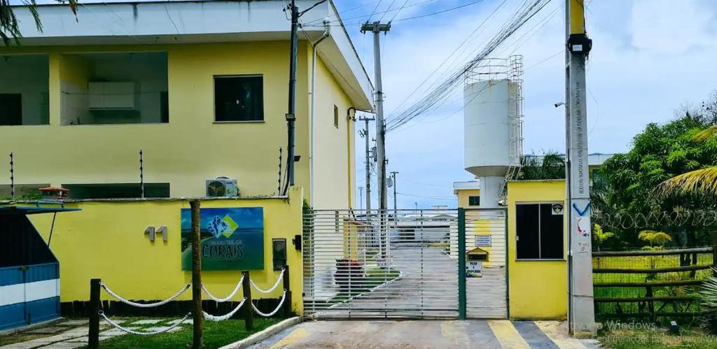 un edificio amarillo con una escalera delante en Praia dos Corais - Bahia en Coroa Vermelha