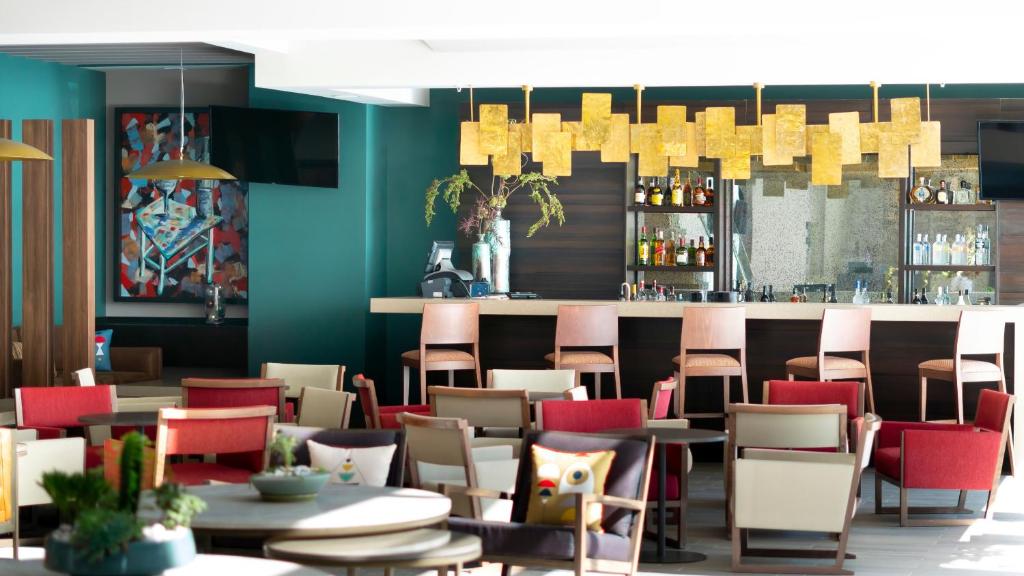 a restaurant with tables and chairs and a bar at Metria Hotel in León