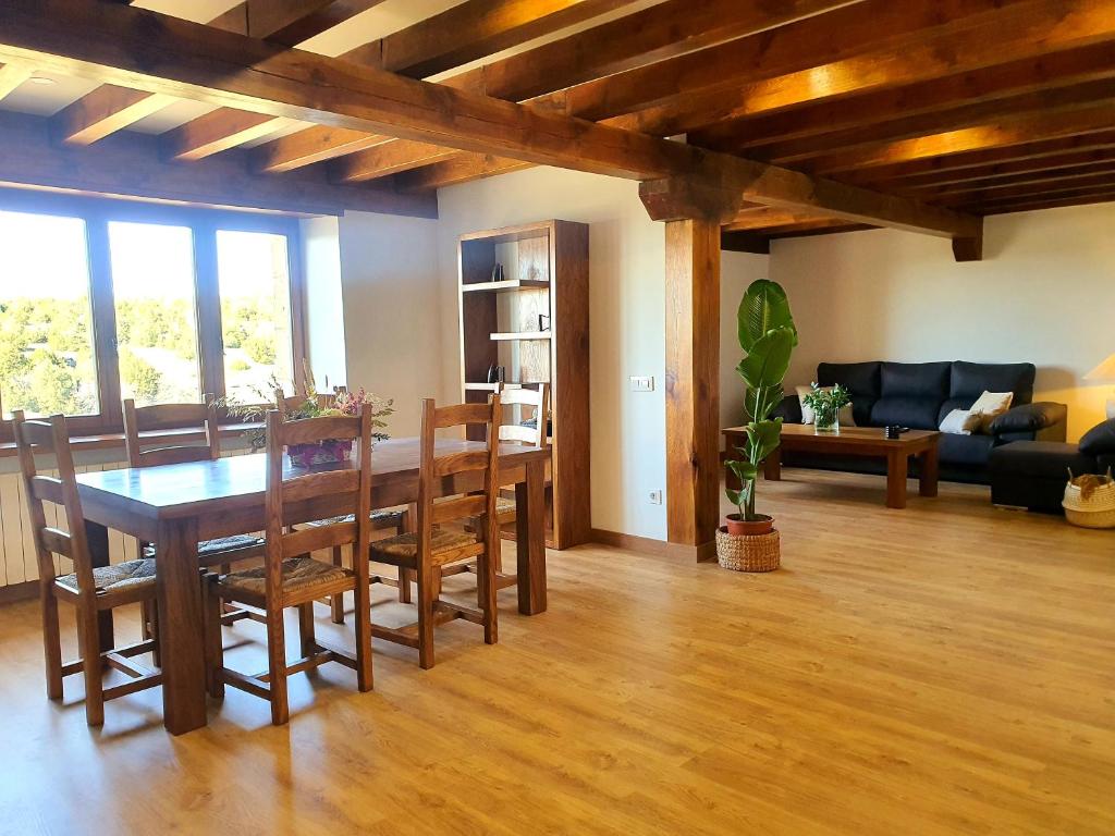 a dining room and living room with a table and chairs at NATVI in Pedraza-Segovia