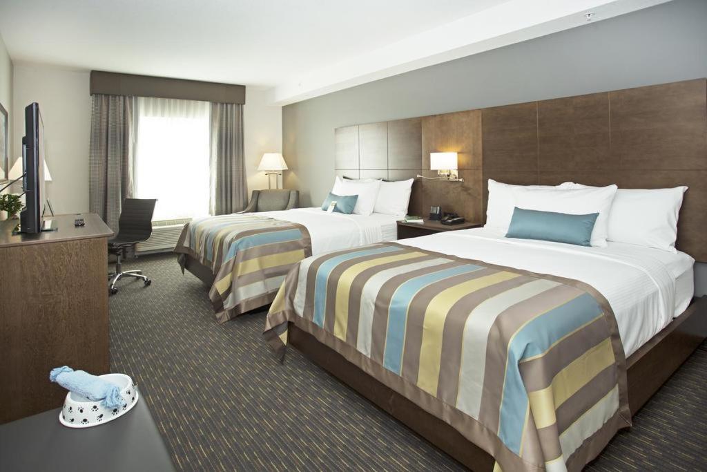 Een bed of bedden in een kamer bij Wingate by Wyndham Calgary Airport