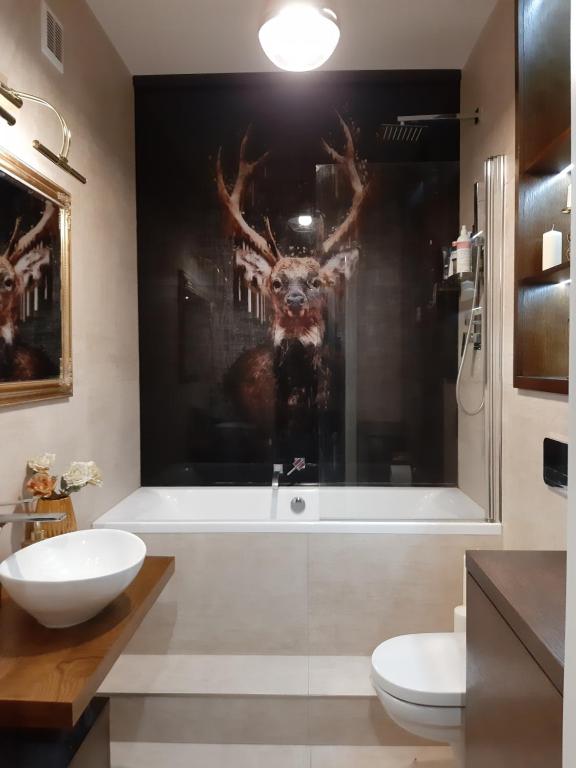 a bathroom with a shower with a picture of a deer on the wall at Lux-house Braniewo in Braniewo