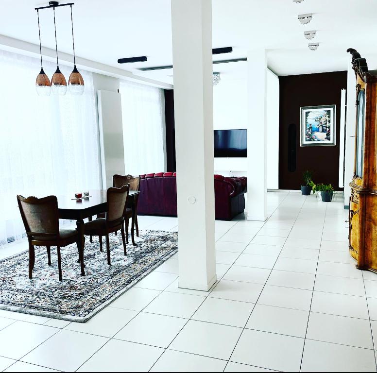 Jaunā Teika Penthouse في ريغا: غرفة معيشة مع طاولة طعام وكراسي