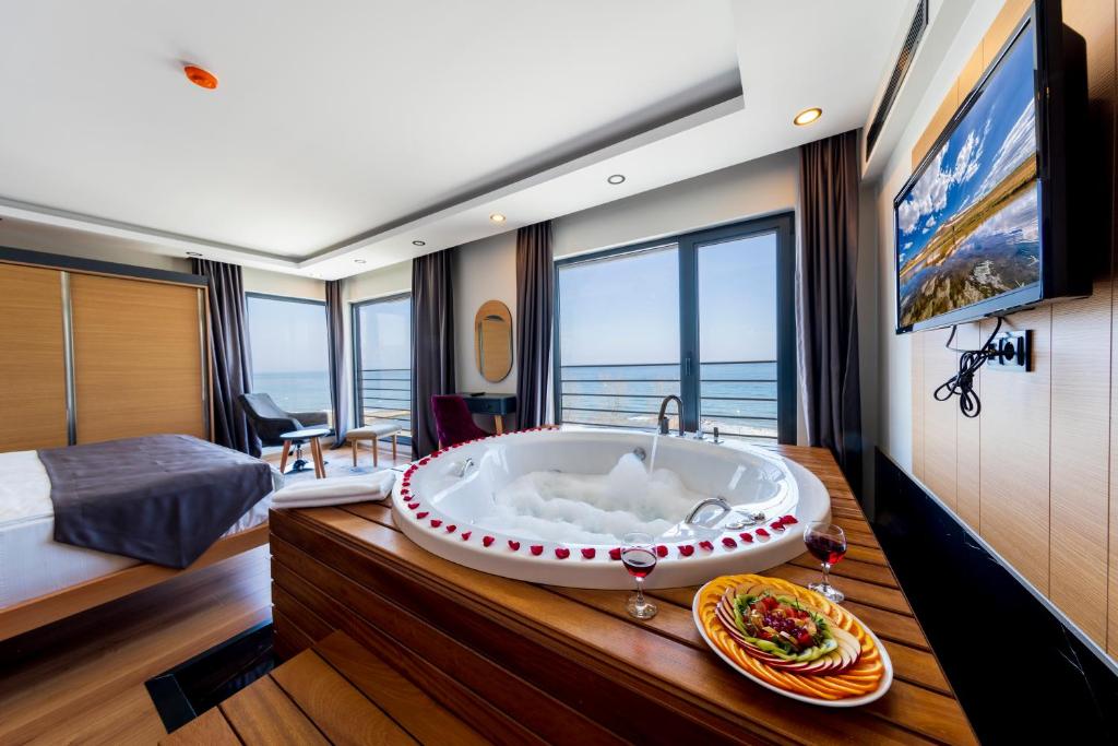 a large bath tub in a room with a bedroom at Şehrar Suite Hotel in Trabzon