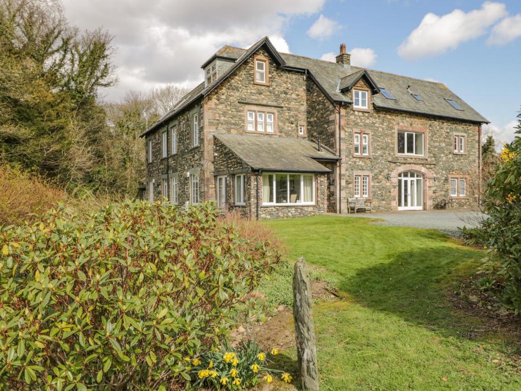 an old stone house with a garden in front of it at Garden Cottage in Keswick