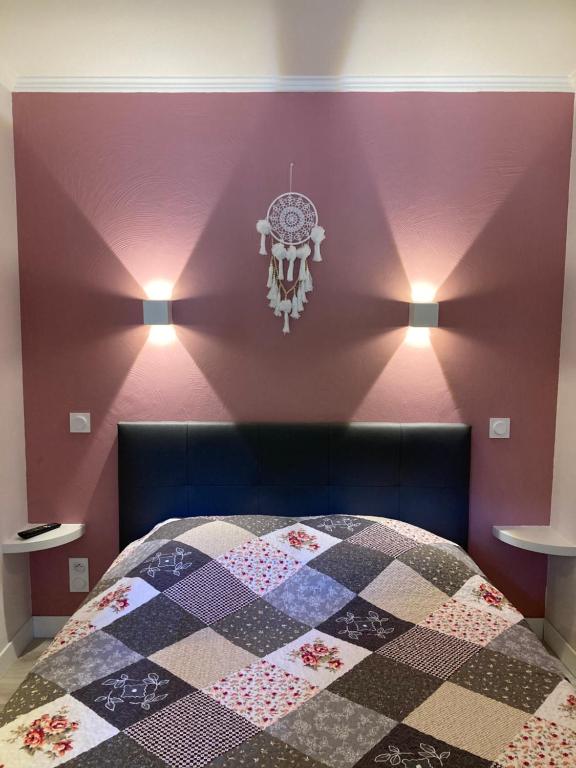 - une chambre avec un lit aux murs violets et un lustre dans l'établissement Les Restanques Bruyeres 2103 proche piscine, à Grimaud