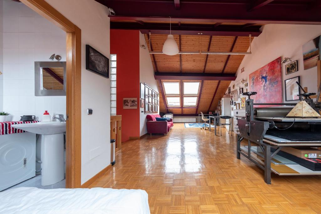 Habitación grande con paredes rojas y suelo de madera. en Duplex en el centro en Oviedo