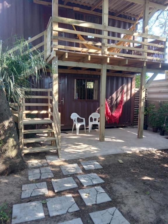 a patio with a wooden pergola and two chairs at Recuerdos in Atlántida