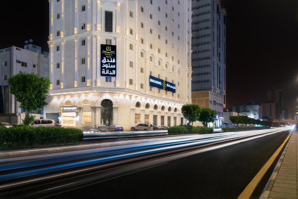 a city street at night with buildings and cars at Snood Al Dana Hotel in Makkah