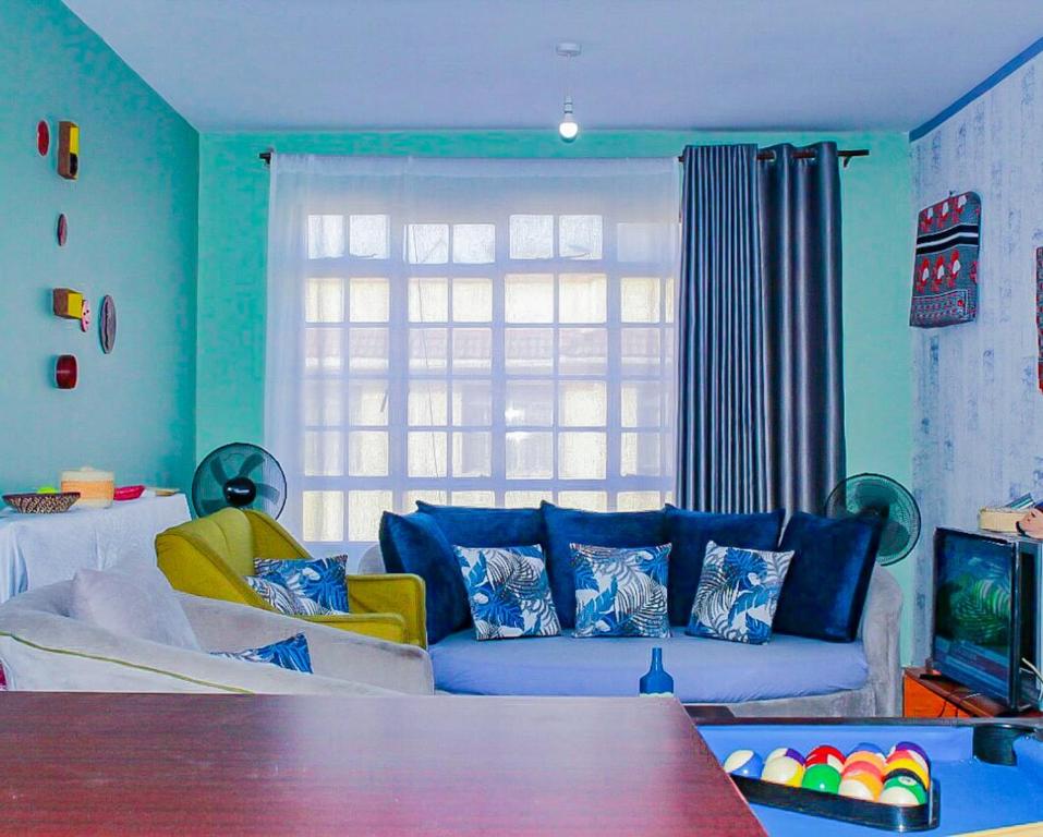 a living room with a couch and a window at Cozy Rooms -JKIA in Syokimau