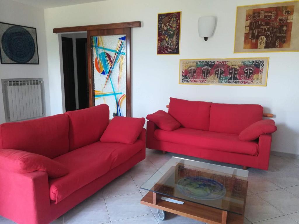 サーレ・マラジーノにあるCASA T.U.A.のリビングルーム(赤いソファ2台、コーヒーテーブル付)