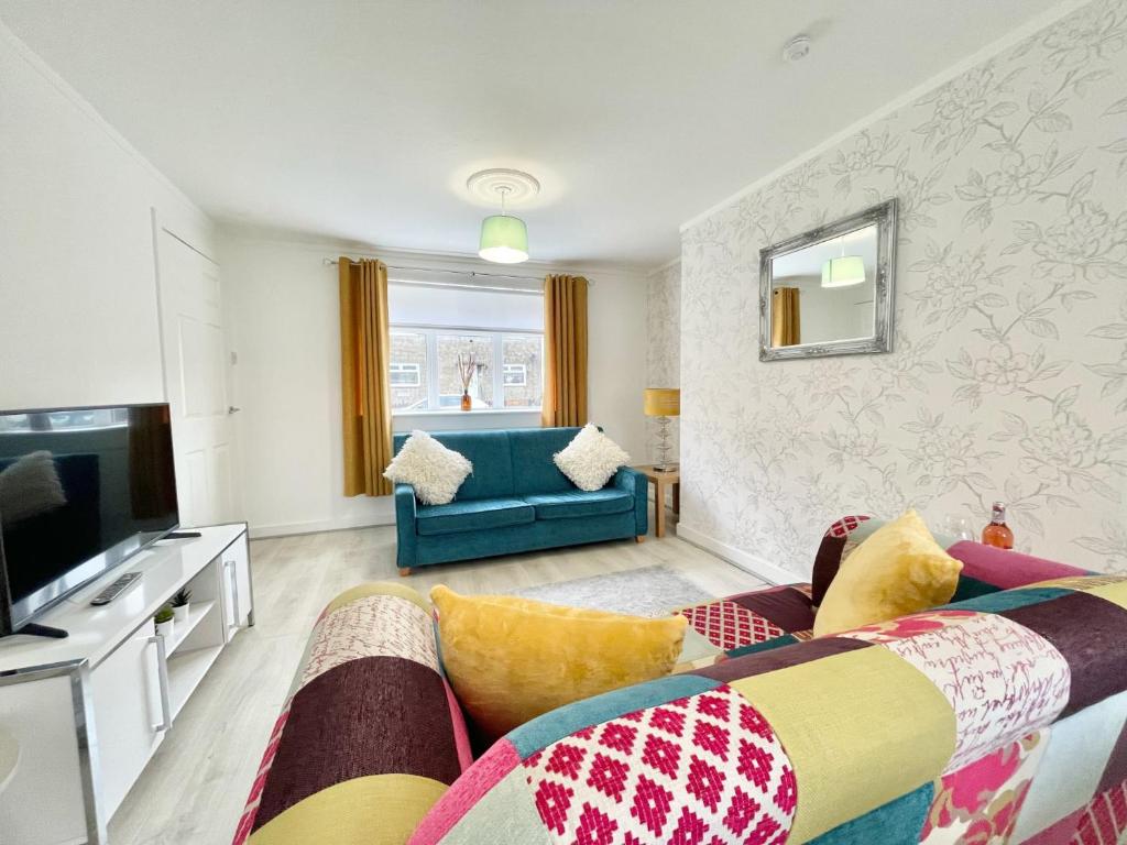 sala de estar con sofá y TV en Hazel House - Vibrant 2 bed house in Wishaw en Wishaw