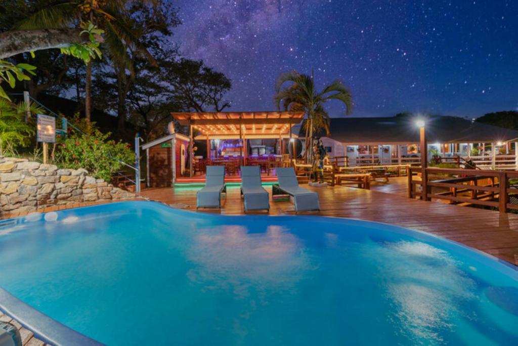 a swimming pool in front of a house at night at Hotel and Dive Center Roatan Yacht Club in Roatan