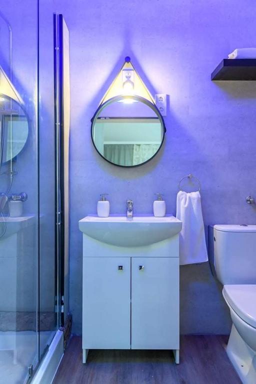 Fioletowa łazienka z umywalką i lustrem w obiekcie Wandorf 125 Apartman w mieście Sopron