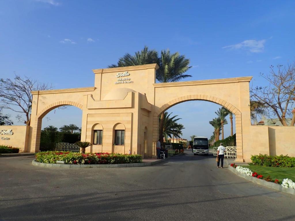 un hombre parado frente a un edificio con un arco en Stella Makadi Palace Chalet en Hurghada