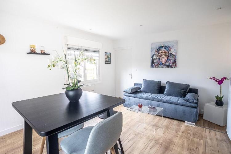 ein Wohnzimmer mit einem blauen Sofa und einem Tisch in der Unterkunft Charmante maison de ville in Périgueux