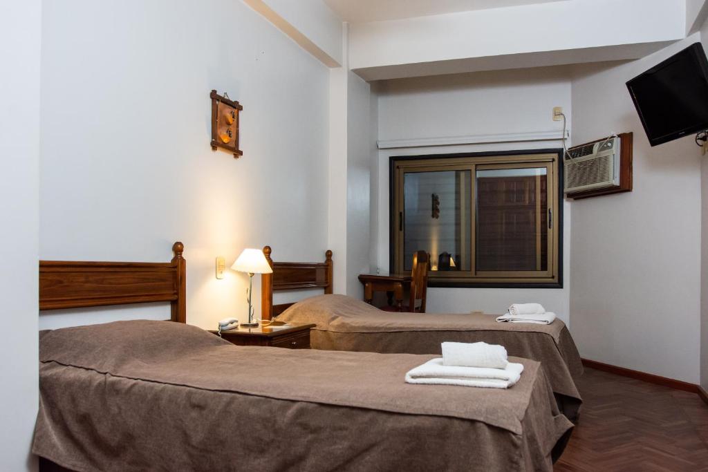 a hotel room with two beds and a television at Catalina Hotel San Pedro de Jujuy in San Pedro de Jujuy