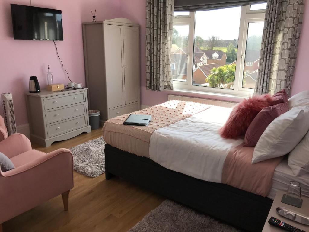 Schlafzimmer mit einem Bett, einem Fenster und einem Stuhl in der Unterkunft The Drey in Sandown