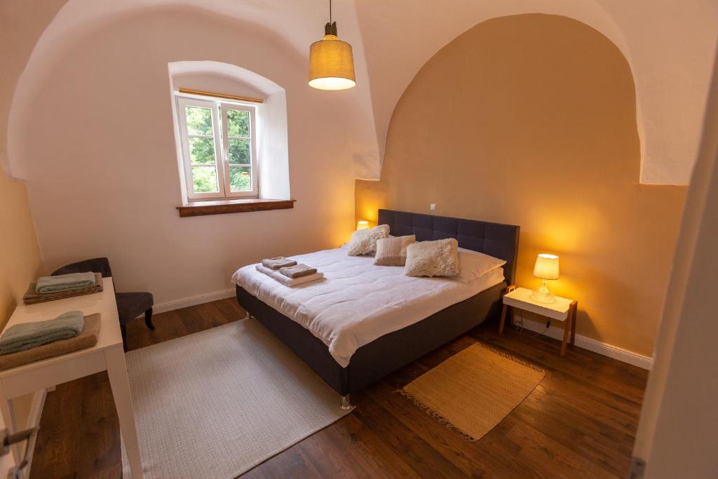 a bedroom with a king sized bed in a room with a window at Pferdegut Schloss Treffen Apartments in Görtschach