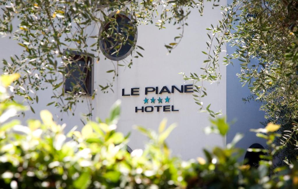 ヴィッランマレにあるHotel Le Pianeのホテルと飛行機を読み取る看板のある建物