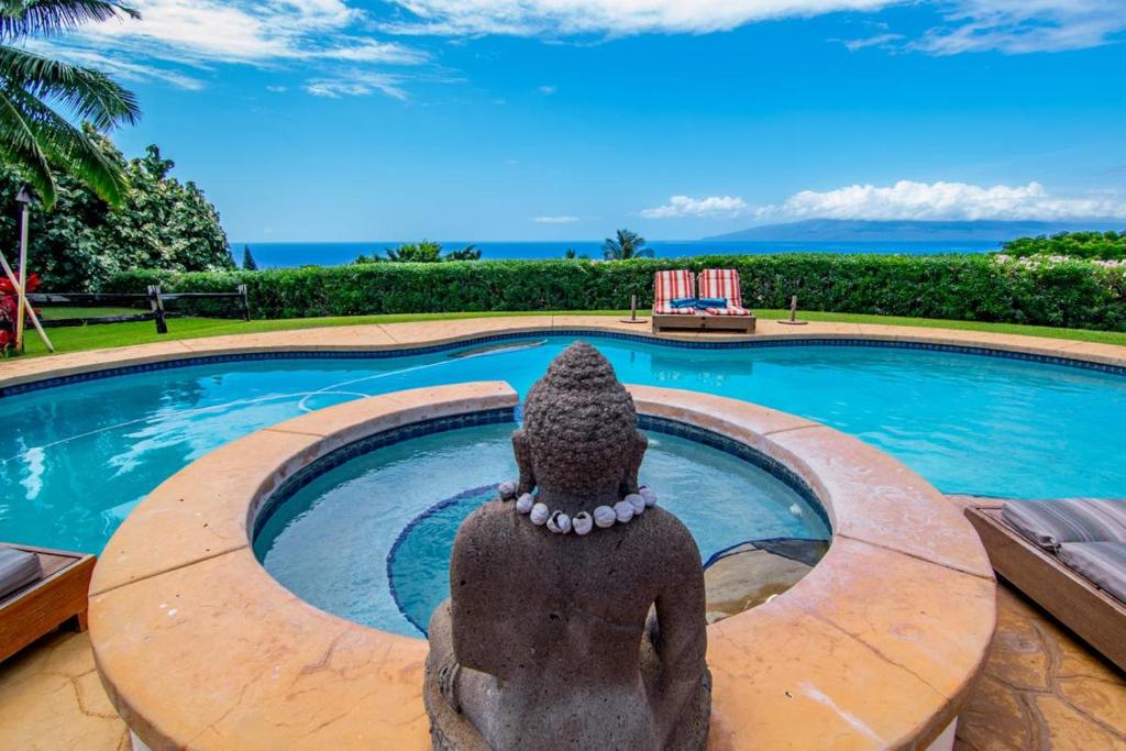 a statue in front of a swimming pool at Makena Aloha Estate in Lahaina