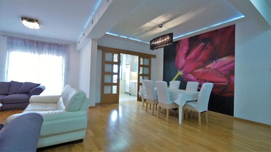 - un salon avec une table, des chaises et un tableau dans l'établissement M&L Lux 3-bedroom apartment (sea view), à Budva