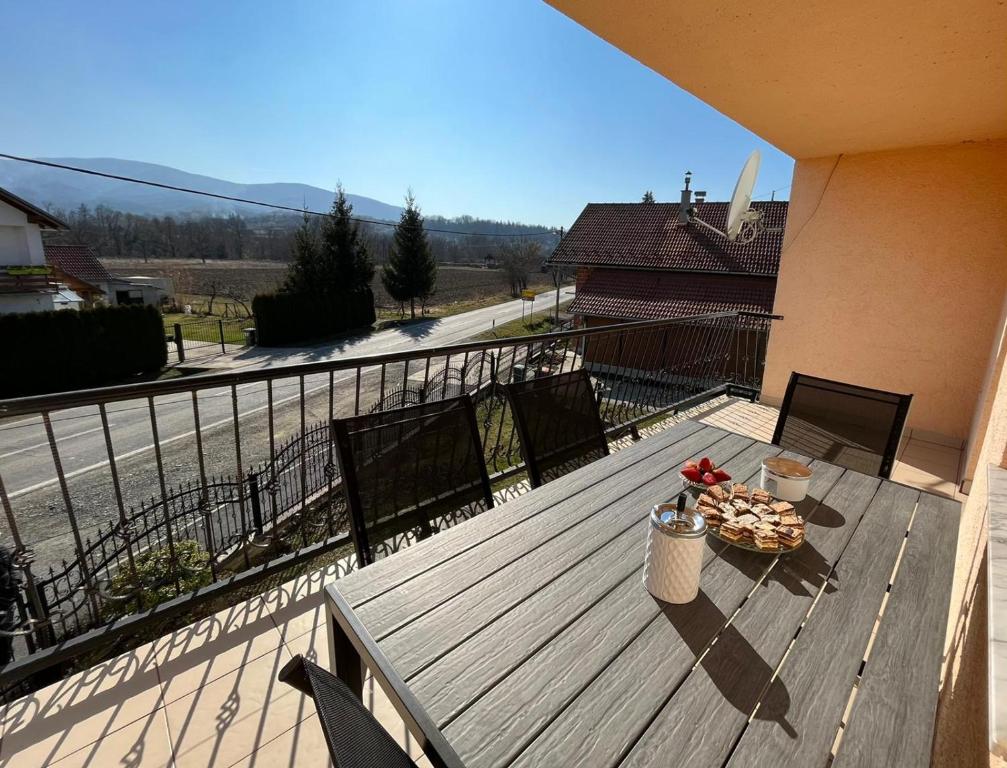 terraza de madera con mesa y sillas en el balcón en Villa Papuk 