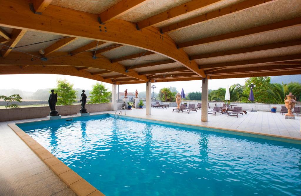 a swimming pool under a pavilion with a swimming pool at San Román de Escalante in Escalante