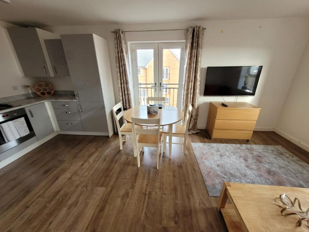 a kitchen and living room with a table and a television at Skylark Apartment in Peacehaven