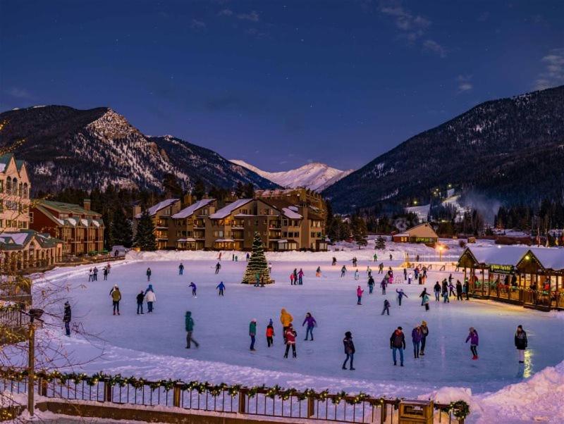 a group of people skating on a rink in the snow at 100-2 Lakeside Village in Keystone