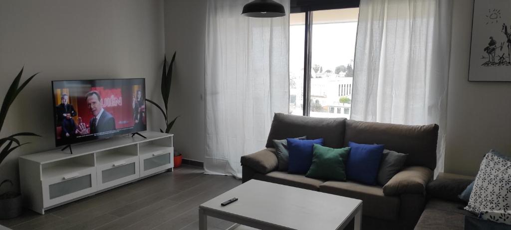 uma sala de estar com um sofá e uma televisão de ecrã plano em Ático en benajarafe em Benajarafe