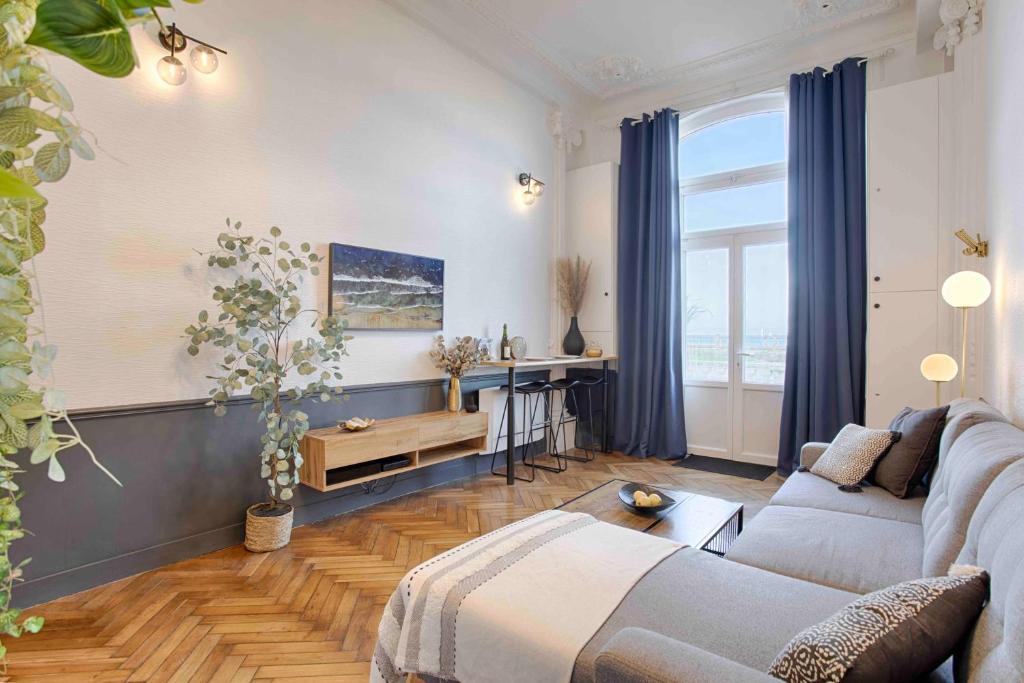 sala de estar con sofá y mesa en WELC'HOME IN HOULGATE - Vue et accès direct sur mer en Houlgate