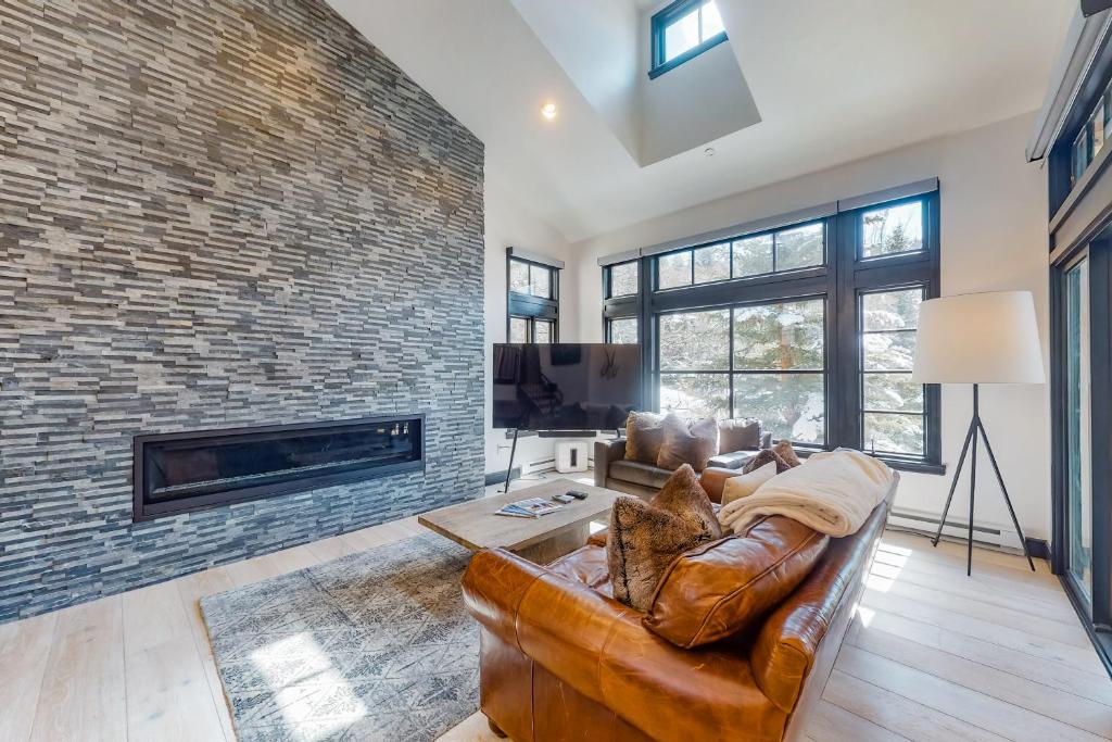 a living room with a couch and a brick wall at Beaver Creeks Meadows Ski-In Ski-Out in Beaver Creek