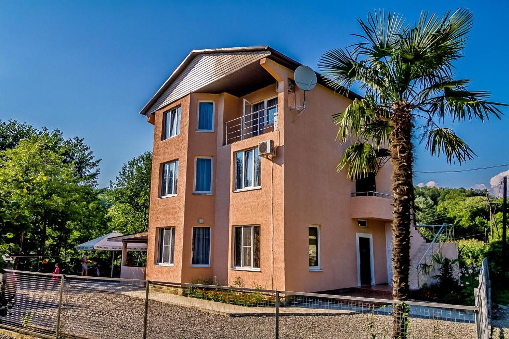 a building with a palm tree in front of it at Guest House Flamenco in Vardane