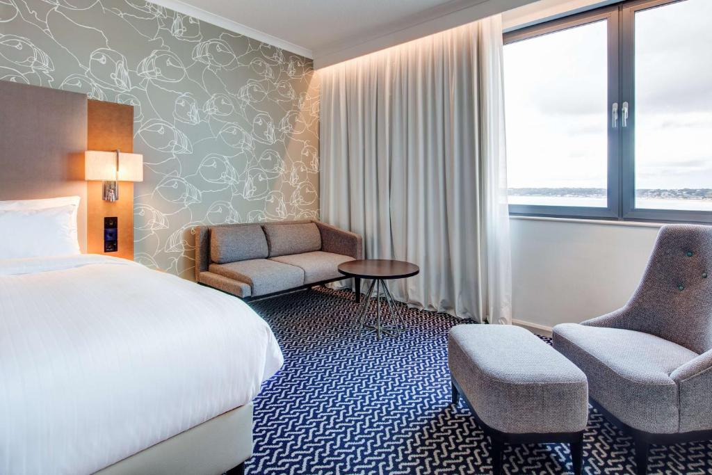 a hotel room with a bed and a chair at Radisson Blu Waterfront Hotel, Jersey in Saint Helier Jersey