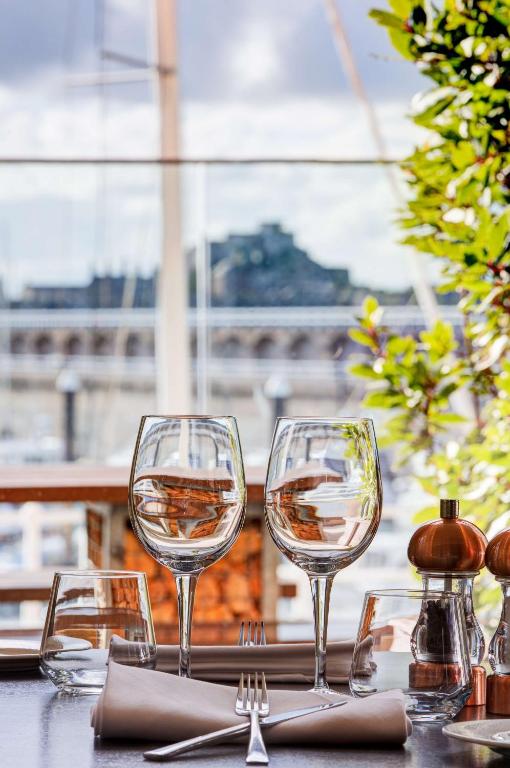 a table with two glasses of wine on it at Radisson Blu Waterfront Hotel, Jersey in Saint Helier Jersey