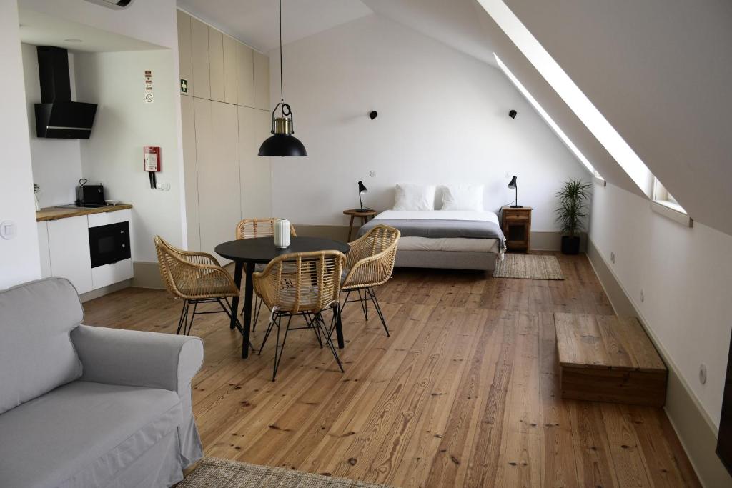 um quarto com uma cama, uma mesa e cadeiras em Venezapartments em Aveiro