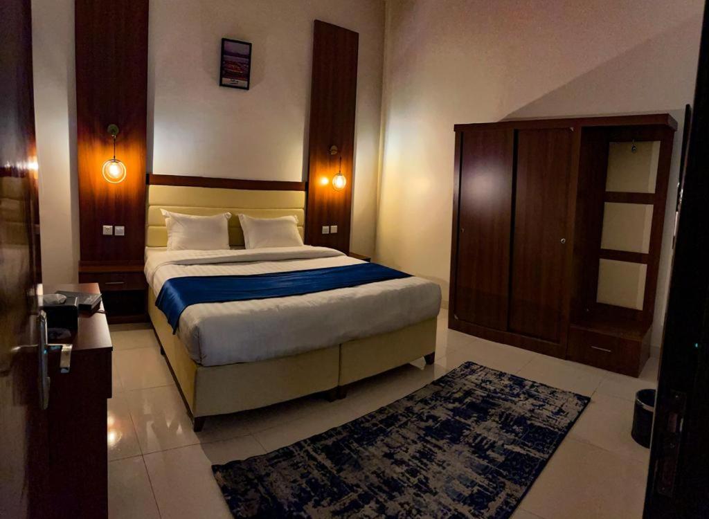 a bedroom with a king sized bed and a rug at Al Mabeet 2 Hotel suites in Abha