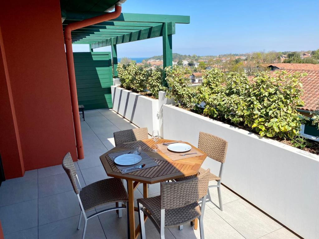 una mesa y sillas en un balcón con vistas en Superbe appartement, grande terrasse vue mer et montagne, en San Juan de Luz