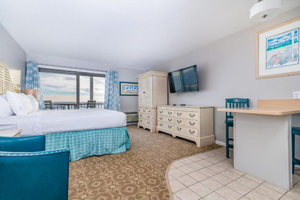 a hotel room with a bed and a television at Sandbars Inn in North Truro