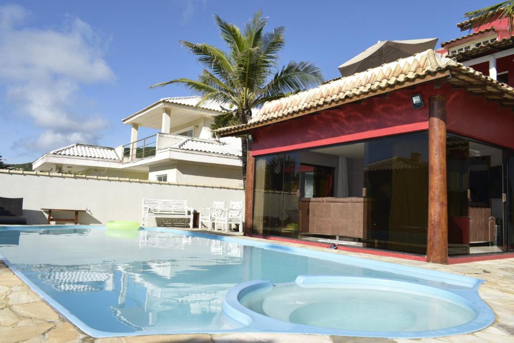 a swimming pool in front of a house at Pousada Sweet Home in Búzios