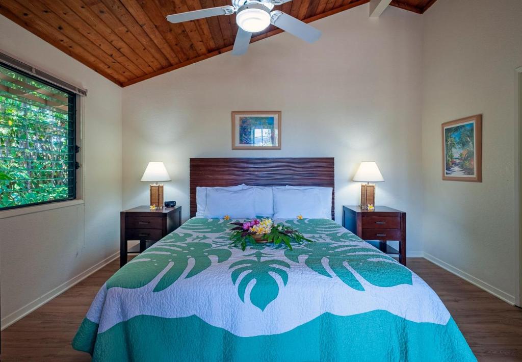 a bedroom with a bed with a flower arrangement on it at Poipu Plantation Vacation Rentals in Koloa